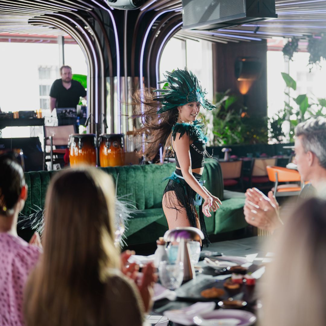 Tollas fejdíszes performer a vendégek között